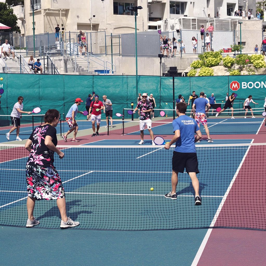 Players enjoying a competitive game of pickleball on court.
